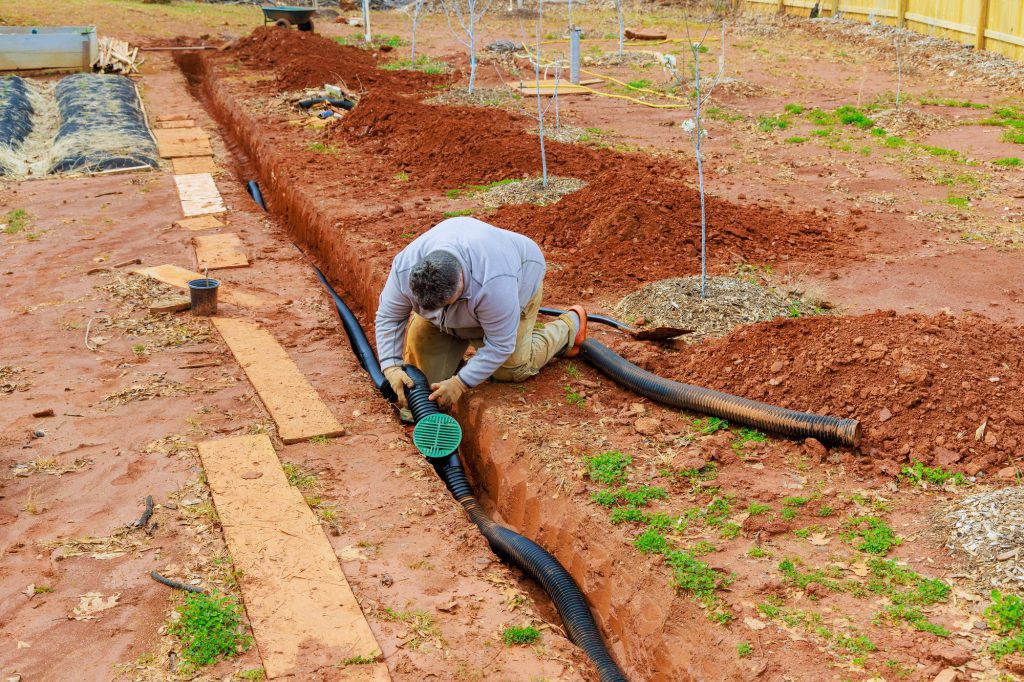 Installing storm drainage drain pipe into a trench drain for draining rainwater